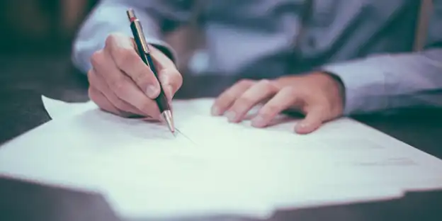 man signing papers