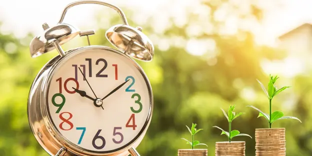 sprouts growing out of coins with clock next to them