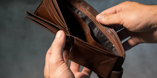 man looking into empty wallet
