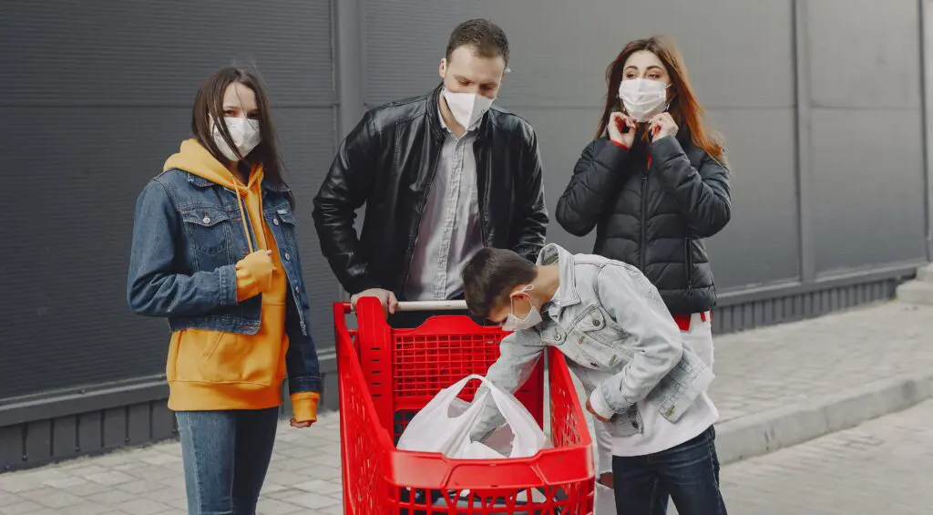 people surrounding red grocery cart