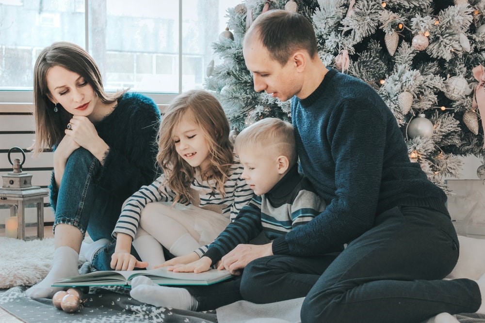 parents helping children open Christmas gifts