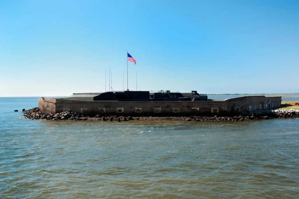 Image shows a wide structure built upon an island with the American flag flying from the top. 